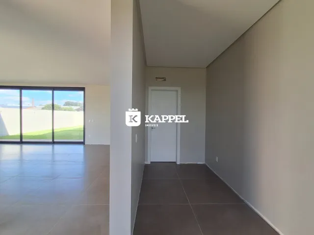 Hall de entrada com paredes brancas e piso claro.
