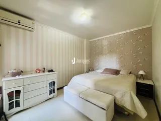Quarto com cama e móveis brancos em um apartamento.