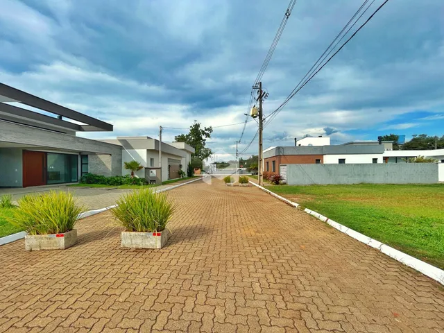 Vista da fachada de uma residência em Lajeado, Brasil, com jardim e calçada de tijolos.