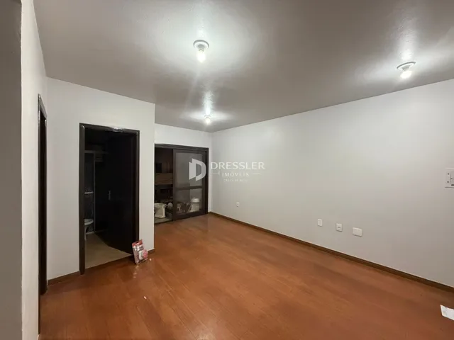 Ambiente interno com piso de madeira e paredes brancas.