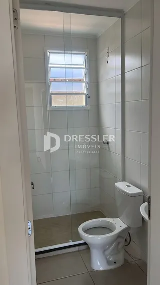 Foto de um banheiro interno com azulejos brancos e janela.