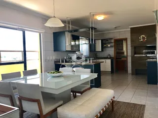 Sala de jantar e cozinha com grandes janelas em um imóvel em Lajeado.