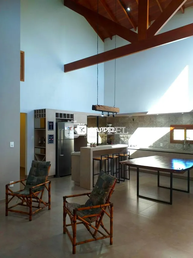Sala de estar com pé direito alto e estrutura de madeira aparente.