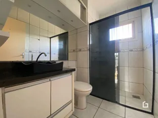 Foto de uma cozinha com armários brancos e bancada escura.