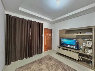 Sala de estar com cortinas escuras e piso claro.
