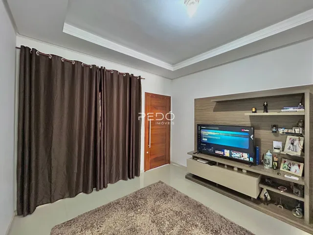 Sala de estar com cortinas escuras e piso claro.