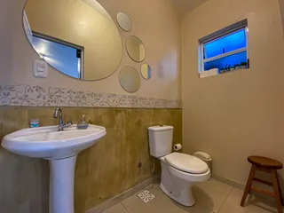 Banheiro com pia branca e vaso sanitário em um imóvel.