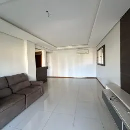 Sala de estar com piso claro e paredes brancas.