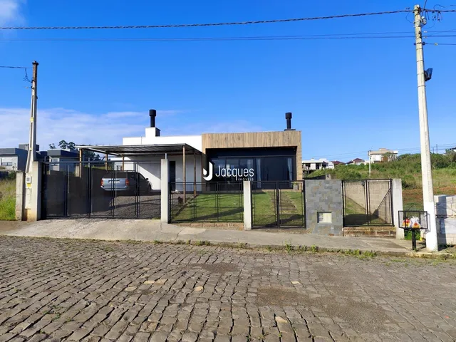 Fachada de uma residência em Lajeado, Brasil, com portão e cerca.