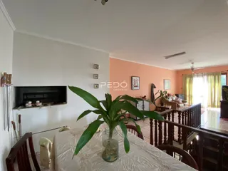 Interior de uma sala com lareira e vista para uma área com piso de cerâmica.