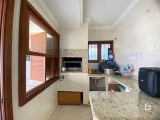 Interior de uma sala com janela e lareira em um imóvel no Brasil.