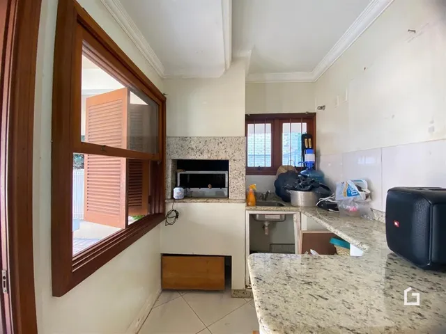 Interior de uma sala com janela e lareira em um imóvel no Brasil.