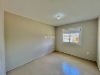Ambiente interno de uma sala com parede lisa e piso claro em um imóvel.