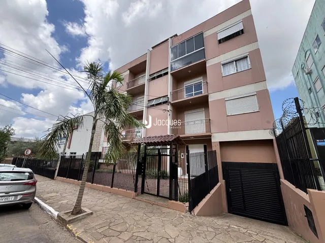 Fachada de um prédio residencial em Lajeado, Brasil, com cerca e vegetação.