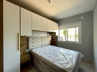 Quarto com armários e cama em um ambiente claro.
