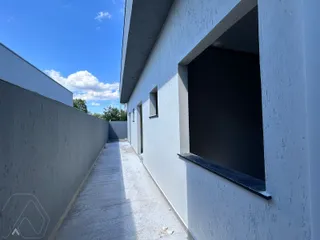 Fachada externa de uma residência com um caminho lateral de concreto.