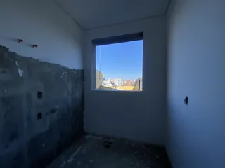 Parede interna com janela que oferece vista para o céu azul.