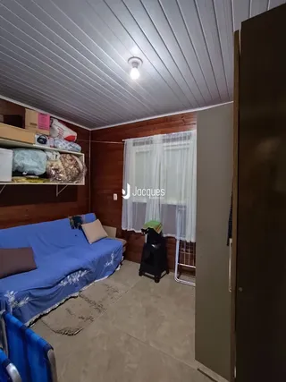 Foto do interior de um quarto com cama e armário de madeira.