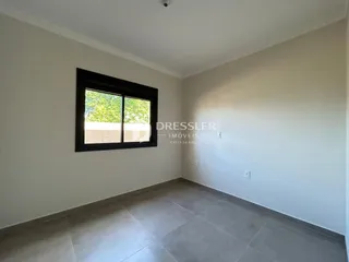 Vista interna de uma sala com piso de cerâmica e janela.