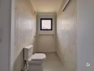 Foto de um banheiro com revestimento em mármore branco.