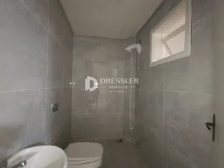 Foto de um banheiro interno com azulejos cinzas e janela.