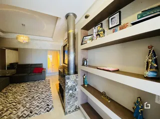 Interior de uma sala com estantes e lareira em um imóvel.