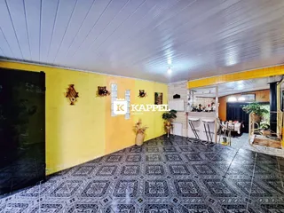 Ambiente interno com piso estampado e paredes amarelas em uma residência.