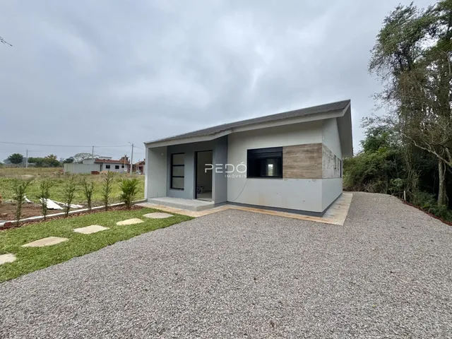 Fachada de uma casa moderna em Lajeado, Brasil, com área de estacionamento de cascalho.
