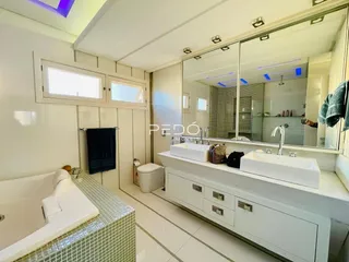 Banheiro moderno com banheira e pias brancas em Lajeado.