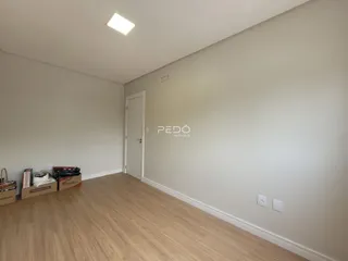 Foto de um cômodo interno com piso de madeira e paredes brancas.