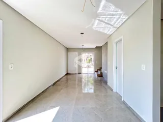 Corredor interno com piso de grandes lajes claras.
