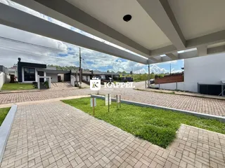 Vista externa da entrada de uma residência em Lajeado, com calçada de tijolos e gramado.
