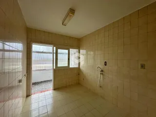 Interior de um cômodo com revestimento cerâmico nas paredes e piso.