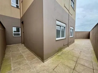 Fachada externa de um prédio com piso de concreto.