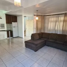 Sala de estar com sofá e piso de cerâmica clara.