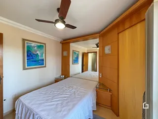 Quarto com cama de casal e decoração de madeira.