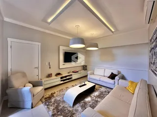Sala de estar moderna com sofá e decoração clara.