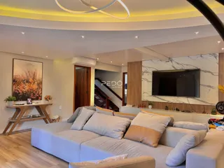 Sala de estar moderna com sofá e piso de madeira em um imóvel no Brasil.