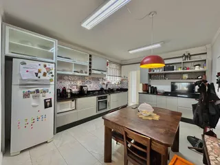 Foto de uma cozinha com armários brancos e bancadas escuras em Lajeado.