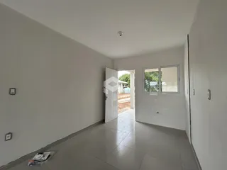 Hall de entrada com piso de cerâmica e paredes brancas.