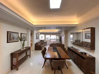Sala de estar com mesa de jantar de madeira e móveis.