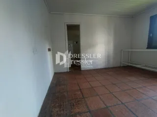Vista interna de um corredor com piso de cerâmica.
