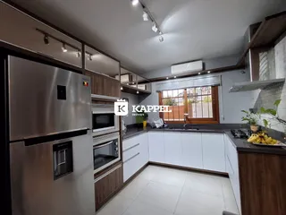 Cozinha moderna com armários de madeira e bancadas escuras.