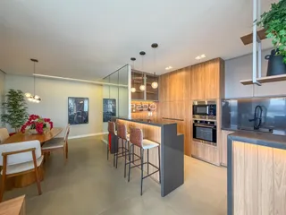 Cozinha moderna com ilha e armários de madeira em um apartamento no Brasil.