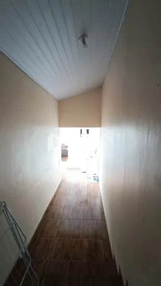 Foto de um corredor interno com piso de cerâmica.