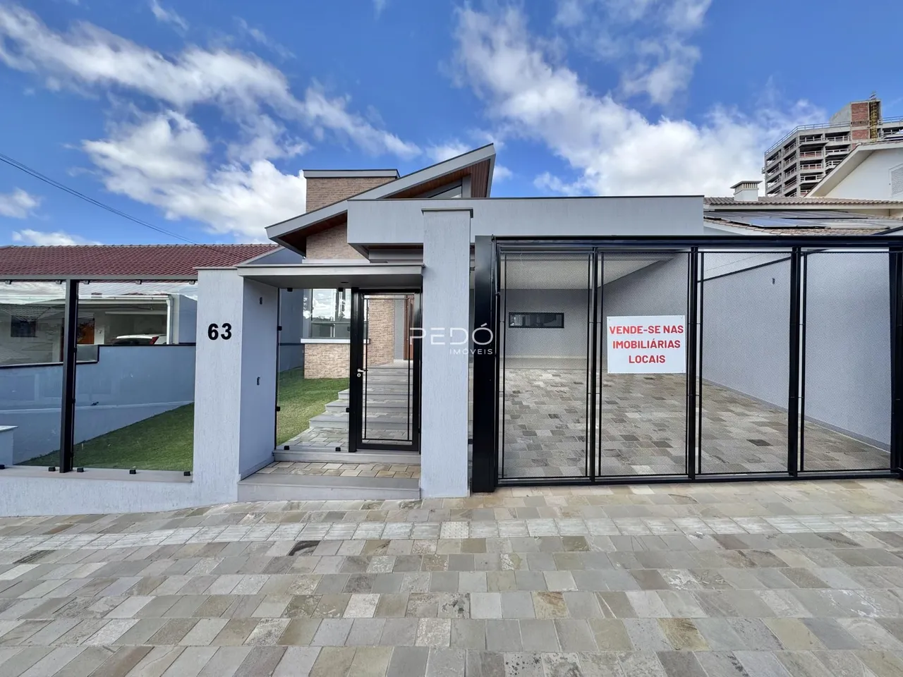 Fachada de uma residência moderna em Lajeado, Brasil, com área externa pavimentada.
