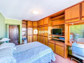Quarto com cama e armários de madeira em um imóvel.