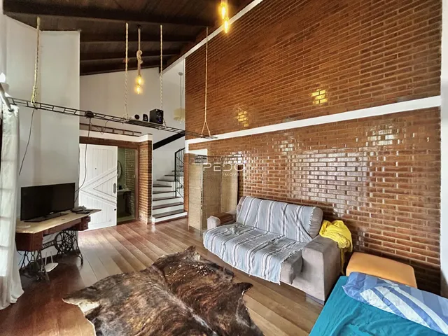 Sala de estar com piso de madeira e parede de tijolos aparentes.