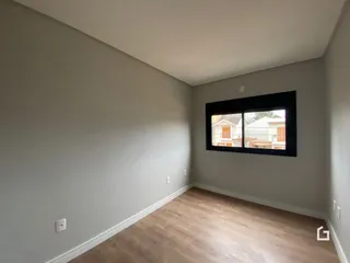 Ambiente interno com paredes cinzas e piso de madeira clara.
