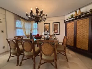 Uma sala de jantar com mesa de madeira e lustre.